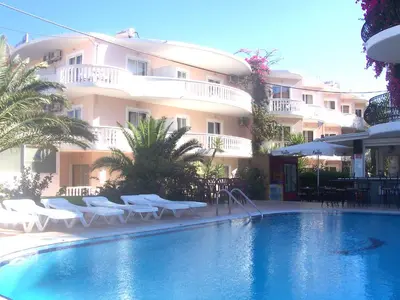a hotel with a swimming pool in front of a building at White Palace Pavlos apartment1 in Faliraki