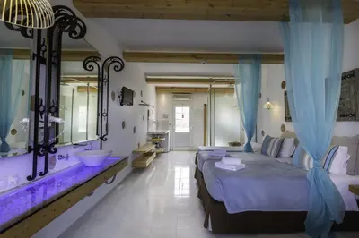 a bedroom with a bed and a sink and a mirror at Lindos View Hotel in Líndos