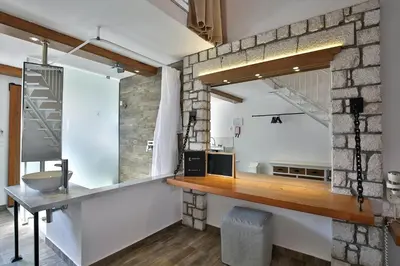 a bathroom with a stone wall and a sink at Lindos View Hotel in Líndos