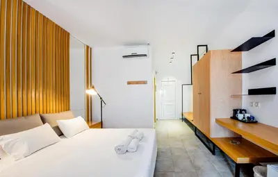 a bedroom with a white bed and a desk at Lindos View Hotel in Líndos