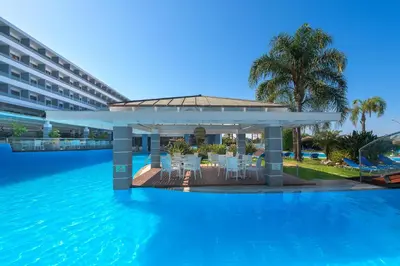 a swimming pool with a gazebo next to a resort at Oceanis Beach Hotel in Ixia
