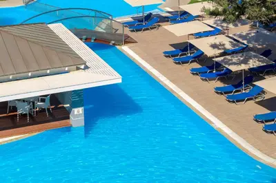 an overhead view of a pool with chairs and umbrellas at Oceanis Beach Hotel in Ixia