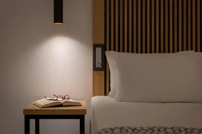 a bed with a book and pair of glasses on a table at Oceanis Beach Hotel in Ixia