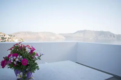 a vase filled with flowers sitting on top of a table at Marea Apartments in Symi