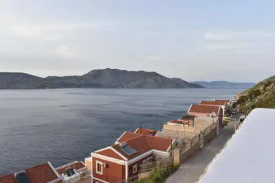 a row of houses next to a body of water at Marea Apartments in Symi