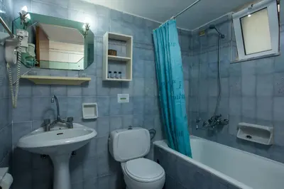 a bathroom with a toilet a sink and a bath tub at CASA MIKELE by Sarikas - SEA SIDE SUITES and STUDIOS -adults only in Faliraki