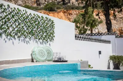 a table and chairs next to a swimming pool at CASA MIKELE by Sarikas - SEA SIDE SUITES and STUDIOS -adults only in Faliraki