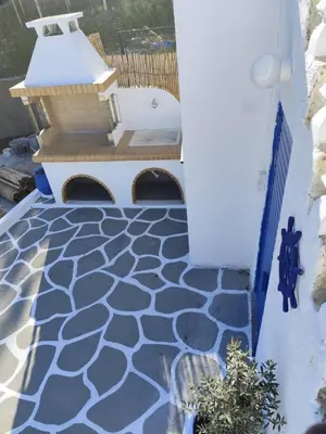 a patio with a blue and white tile floor at Sea Breeze Stegna in Archangelos