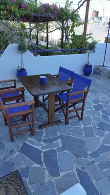 a wooden table and two chairs and a wooden table and chairs at Sea Breeze Stegna in Archangelos
