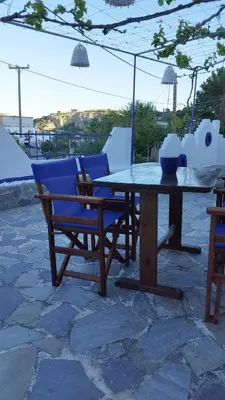 a wooden table and chairs sitting on a patio at Sea Breeze Stegna in Archangelos