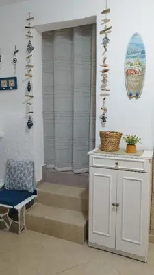 a room with a table and a chair and stairs at Sea Breeze Stegna in Archangelos