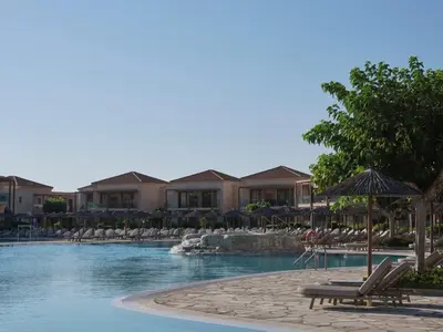 a pool with chairs and umbrellas in a resort at Atlantica Aegean Park in Kolimbia