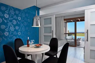a dining room with a white table and black chairs at Atlantica Aegean Park in Kolimbia