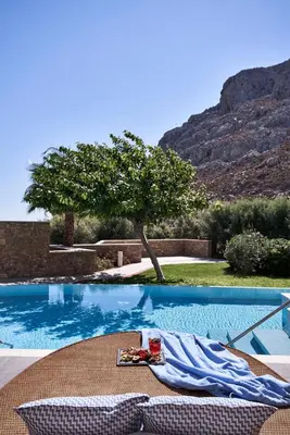 a swimming pool with a table and chairs next to it at Atlantica Aegean Park in Kolimbia