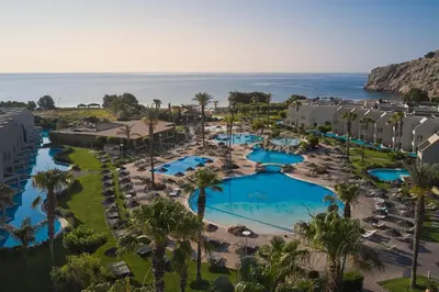 an aerial view of a resort with a pool and the ocean at Atlantica Aegean Blue in Kolimbia