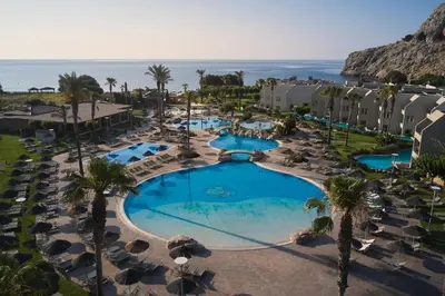 an aerial view of a resort with a pool and the ocean at Atlantica Aegean Blue in Kolimbia