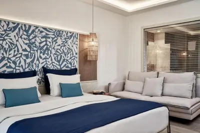 a bedroom with a large bed and a couch at Atlantica Aegean Blue in Kolimbia