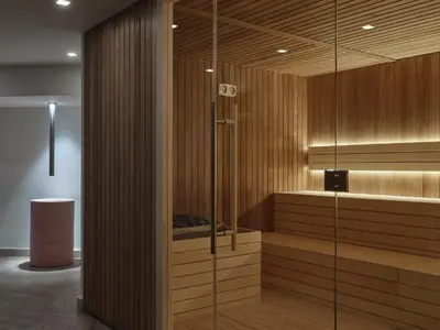 a sauna with wooden walls and a glass door at Atlantica Aegean Blue in Kolimbia