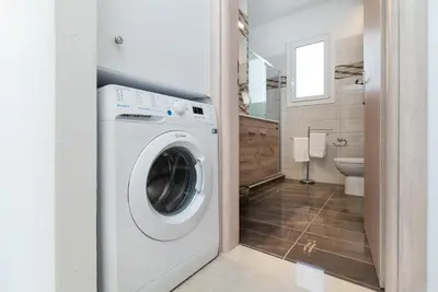 a white washer and dryer in a bathroom at South Beach Villas in Gennadi