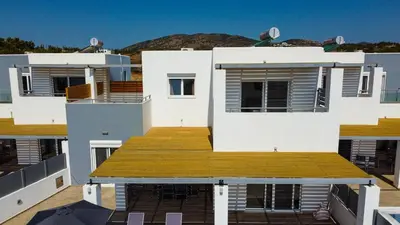 a large white house with a wooden deck at South Beach Villas in Gennadi