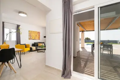 a living room with a sliding glass door leading to a patio at South Beach Villas in Gennadi