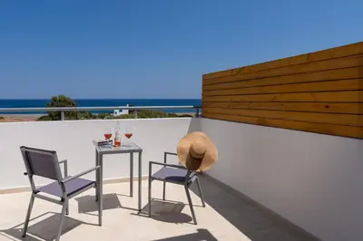 a table and two chairs on a balcony with the ocean at South Beach Villas in Gennadi
