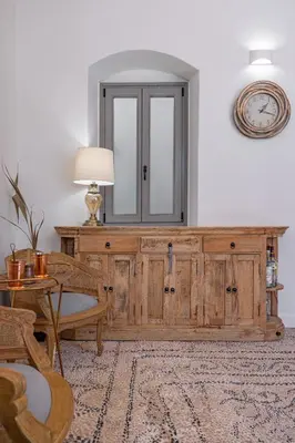 a large wooden cabinet in a living room with a table at Melitia Traditional House in Koskinou