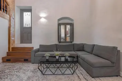 a living room with a gray couch and a mirror at Melitia Traditional House in Koskinou