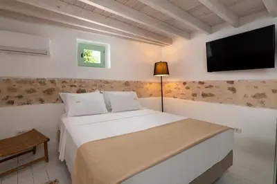 a bedroom with a bed with a flat screen tv at Dipagio Origin Villa in Lachania