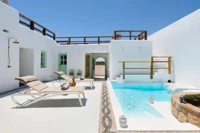 a patio with chairs and a swimming pool at Dipagio Origin Villa in Lachania