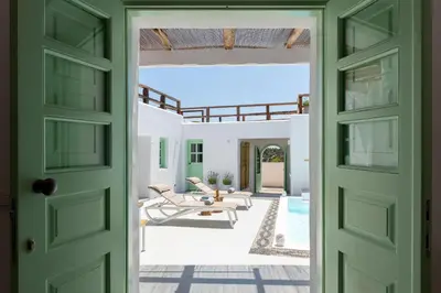 an open door to a patio with chairs and a pool at Dipagio Origin Villa in Lachania