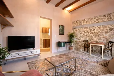 a living room with a television and a stone wall at Casa Emiliana in Rhodes Town
