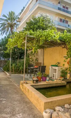 a patio with a table and chairs on the water at Garden House Elli beach 2 min in Rhodes Town