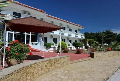 a large white building with a large umbrella at Asterias Bay-Theologos in Theologos