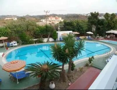 a large swimming pool with palm trees and an umbrella at Asterias Bay-Theologos in Theologos