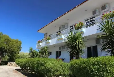 a white building with plants in front of it at Asterias Bay-Theologos in Theologos