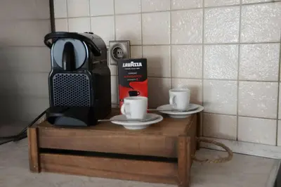 a coffee maker and two cups on a wooden table at Mary's dreams Villa in Symi