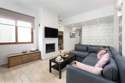 a living room with a blue couch and a fireplace at Ritas Modern In-City House in Rhodes Town