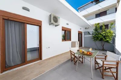 a patio with a table and chairs on a balcony at Ritas Modern In-City House in Rhodes Town