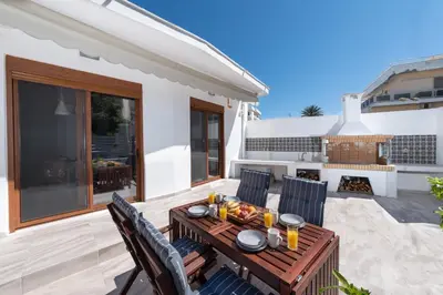 a patio with a table and chairs and a fireplace at Ritas Modern In-City House in Rhodes Town