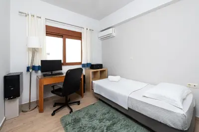 a bedroom with a bed and a desk with a computer at Ritas Modern In-City House in Rhodes Town