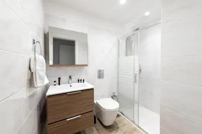 a white bathroom with a toilet and a shower at Ritas Modern In-City House in Rhodes Town