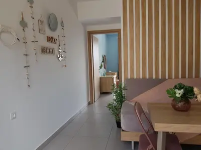 a living room with a table and a dining room at Galazia Thea Apartments in Archangelos