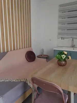 a wooden table with a vase of flowers on it at Galazia Thea Apartments in Archangelos