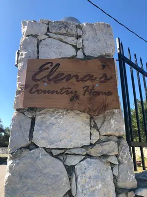 a sign for elena a country home on a stone wall at Elena's Country Home & SPA in Kalithies