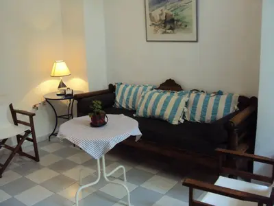 a living room with a black couch and a table at Albatros in Symi