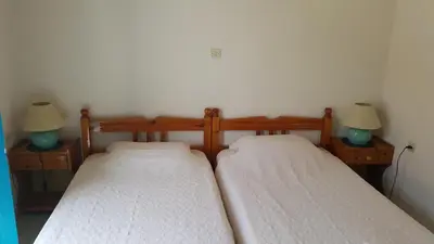 two beds in a room with two lamps at Albatros in Symi