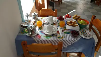 a table with breakfast foods and orange juice on it at Albatros in Symi