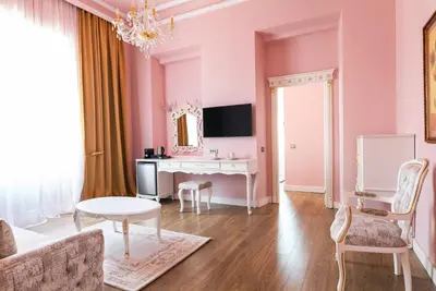 a living room with pink walls and a desk at Via Villa Iliotti Rhodos in Rhodes Town