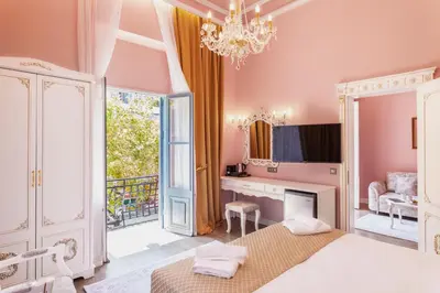 a bedroom with a bed and a desk and a mirror at Via Villa Iliotti Rhodos in Rhodes Town